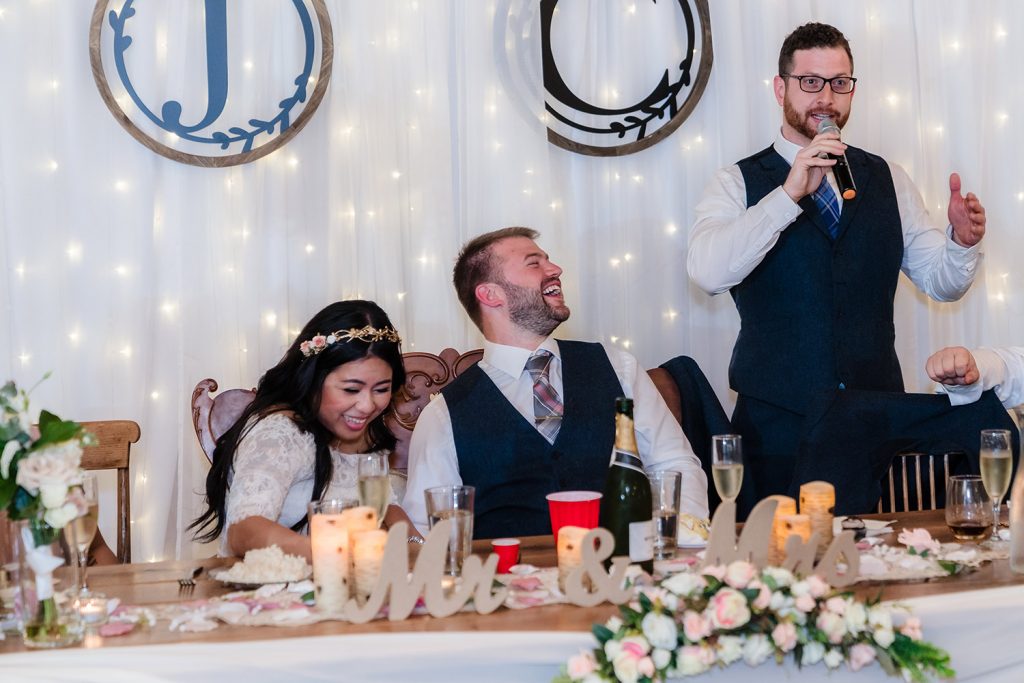 Bride and groom laughing during Best Man's speech