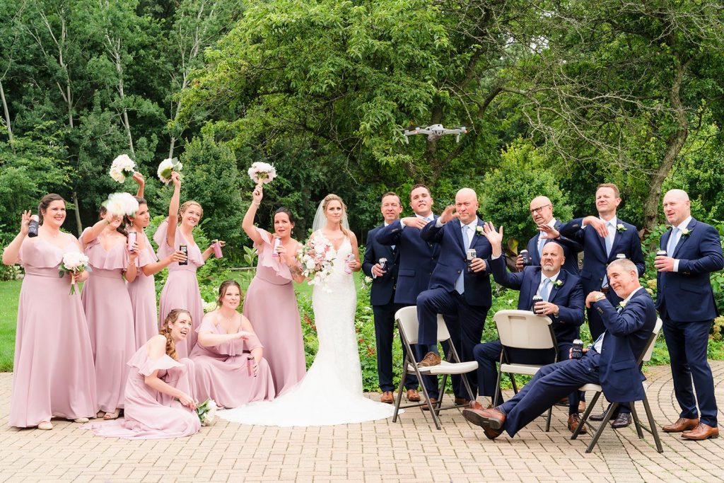 Bridal party playfully swat at a drone