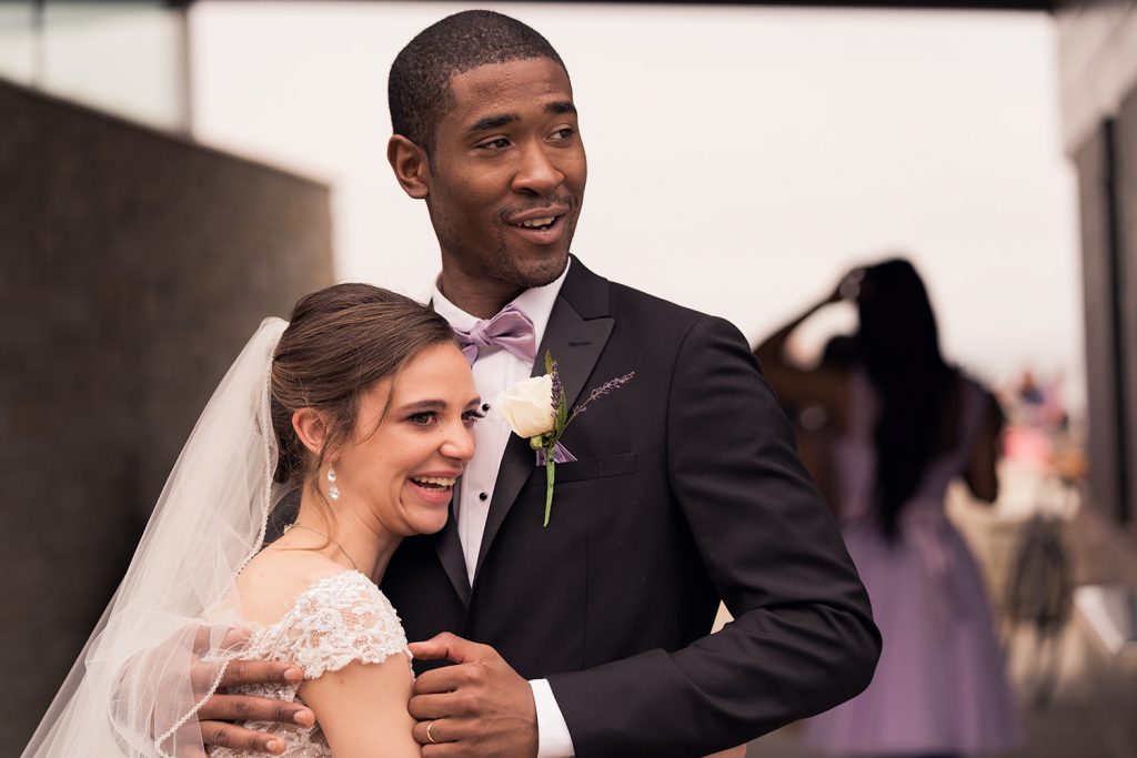 Bride and groom smiling at family and friends after the wedding ceremony