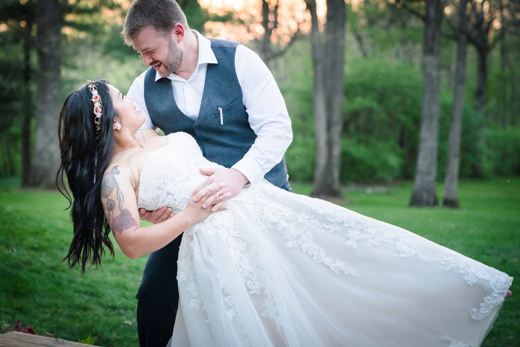 Bride and groom do a dip pose at Kilbuck Creek in Monroe, IL