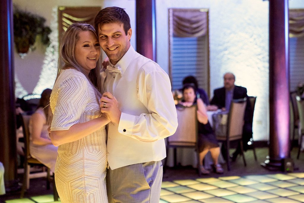 Bride and groom smiling at guest during First Dance