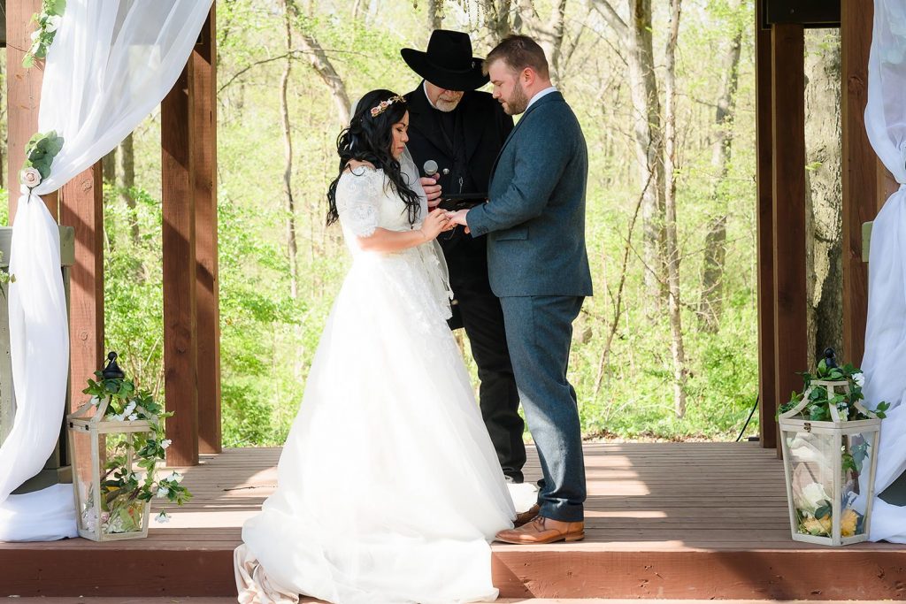 Bride and groom ring exchange during the wedding ceremony at Kilbuck Creek in Monroe, IL