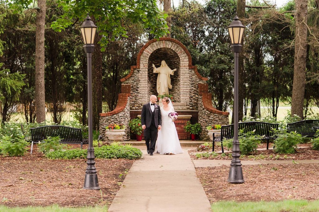 Bride and groom walking at the National Shrine of St. Maximilian Kolbe