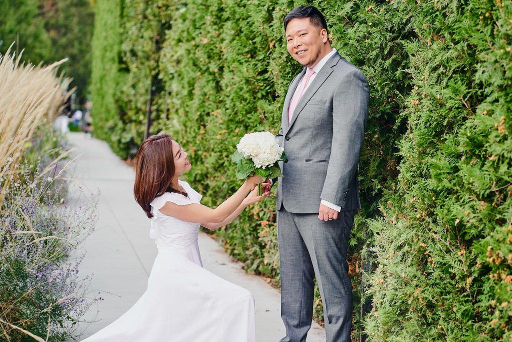 Bride offers groom flowers at Millennium Park in Chicago, IL