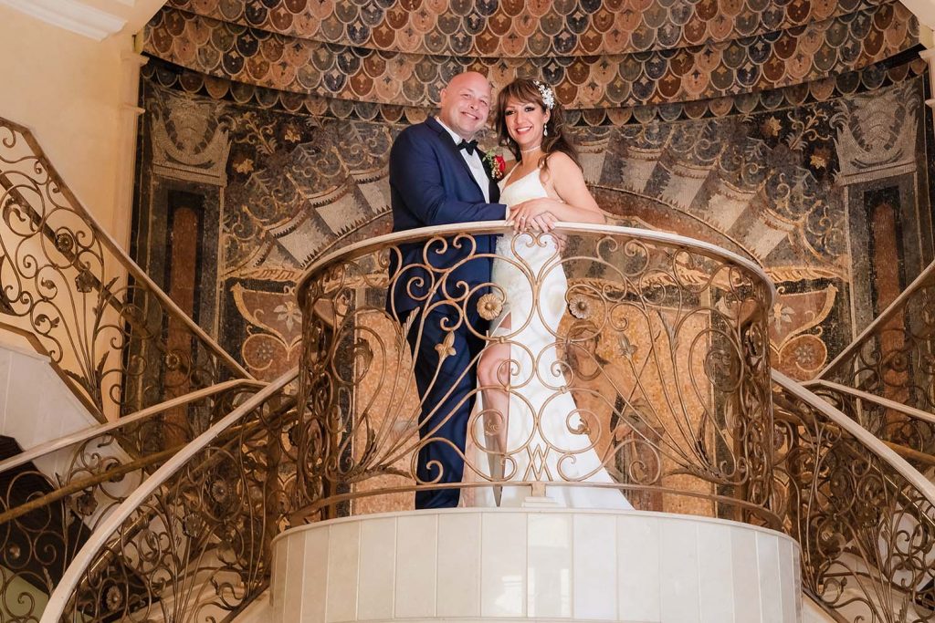 Bride and groom at the top of the staircase at Venuti's in Addison, IL