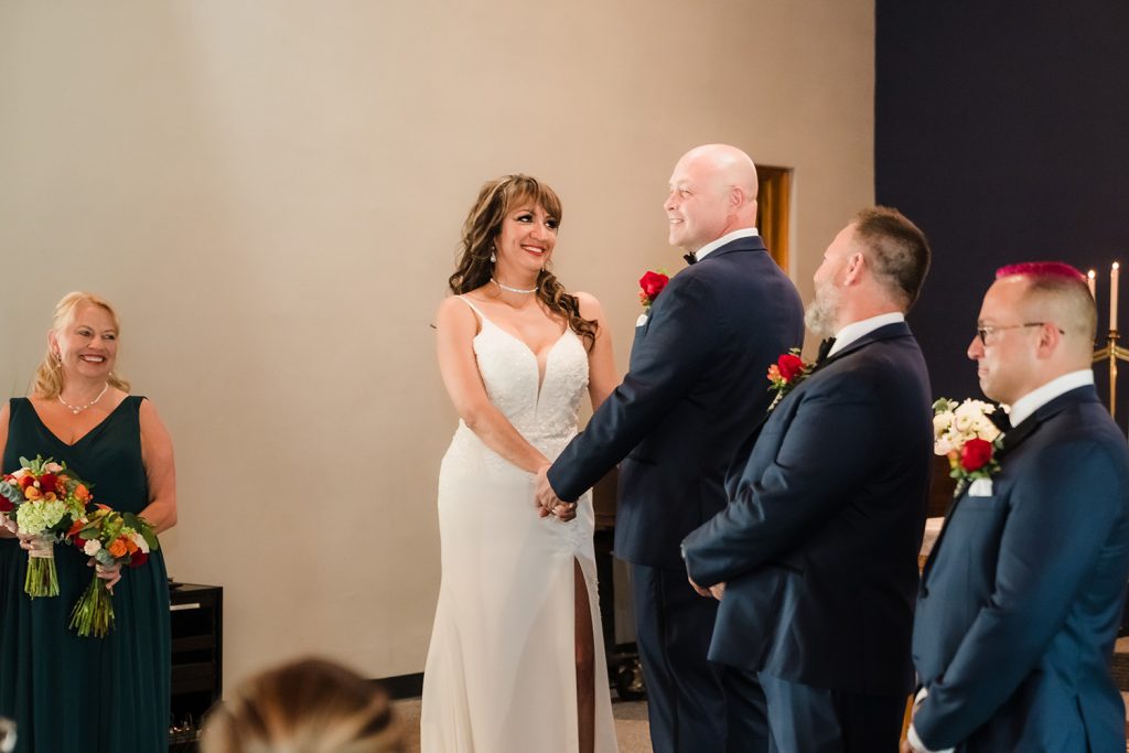 Bride smiling at the groom during the wedding ceremony at The Center in Itasca, IL