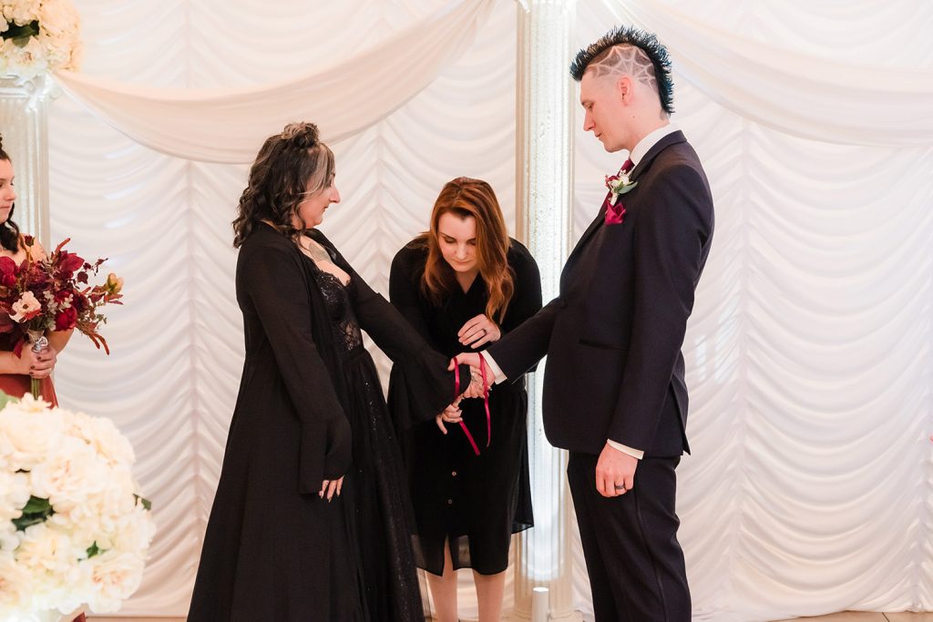 Bride and groom have a pagan handfasting ritual during their ceremony at the Seville in Streamwood, IL