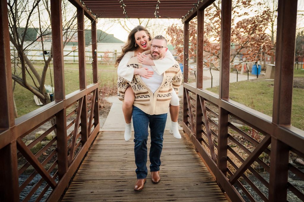 Engaged couple shenanigans on the bridge during their engagement shoot at Lake Katherine in Palos Hills, IL