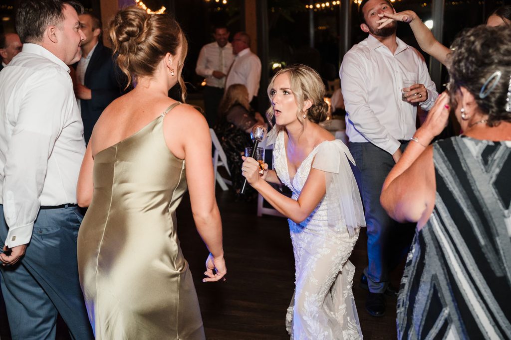 Bride doing karaoke at her wedding reception at Oak Brook Tennis & Bath Club in Oak Brook, IL