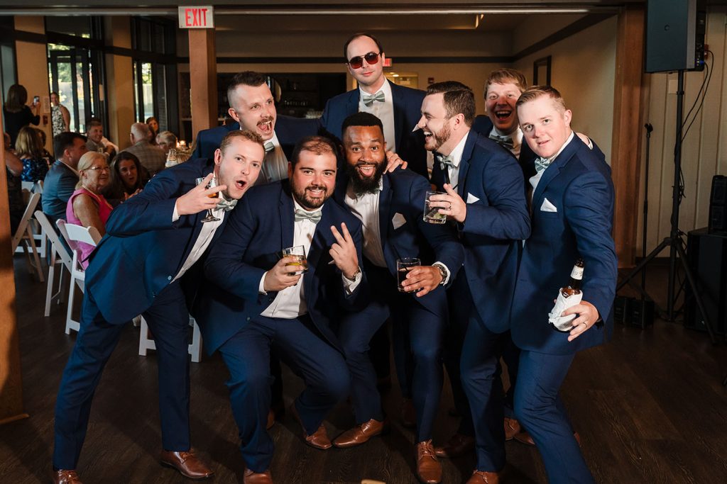 Groomsmen shenanigans during their introduction at Oak Brook Tennis & Bath Club in Oak Brook, IL