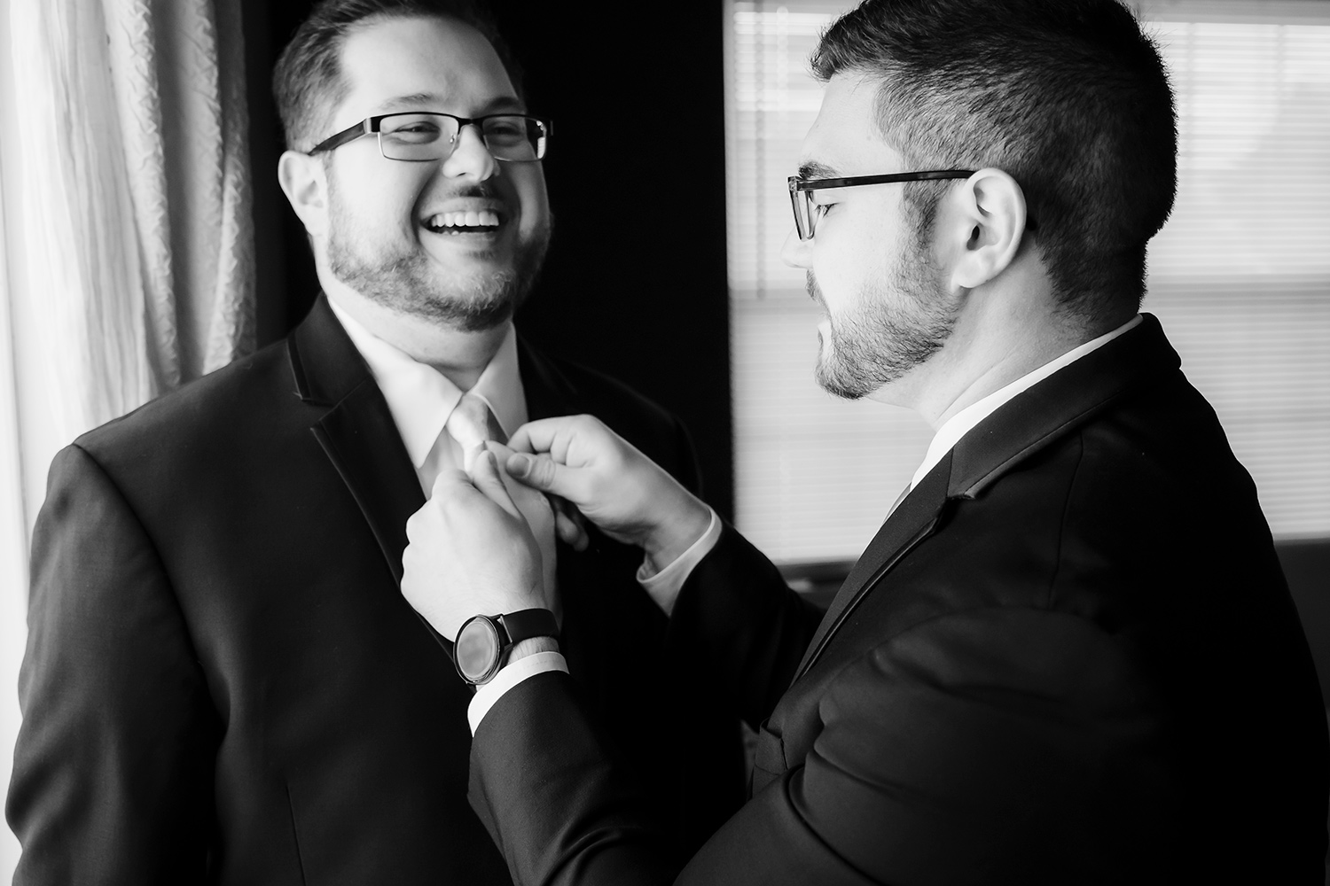 Best man assists groom with tie