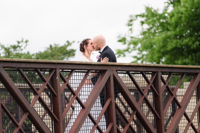 Bride and groom kiss on a bridge at Independence Grove in Libertyville, IL