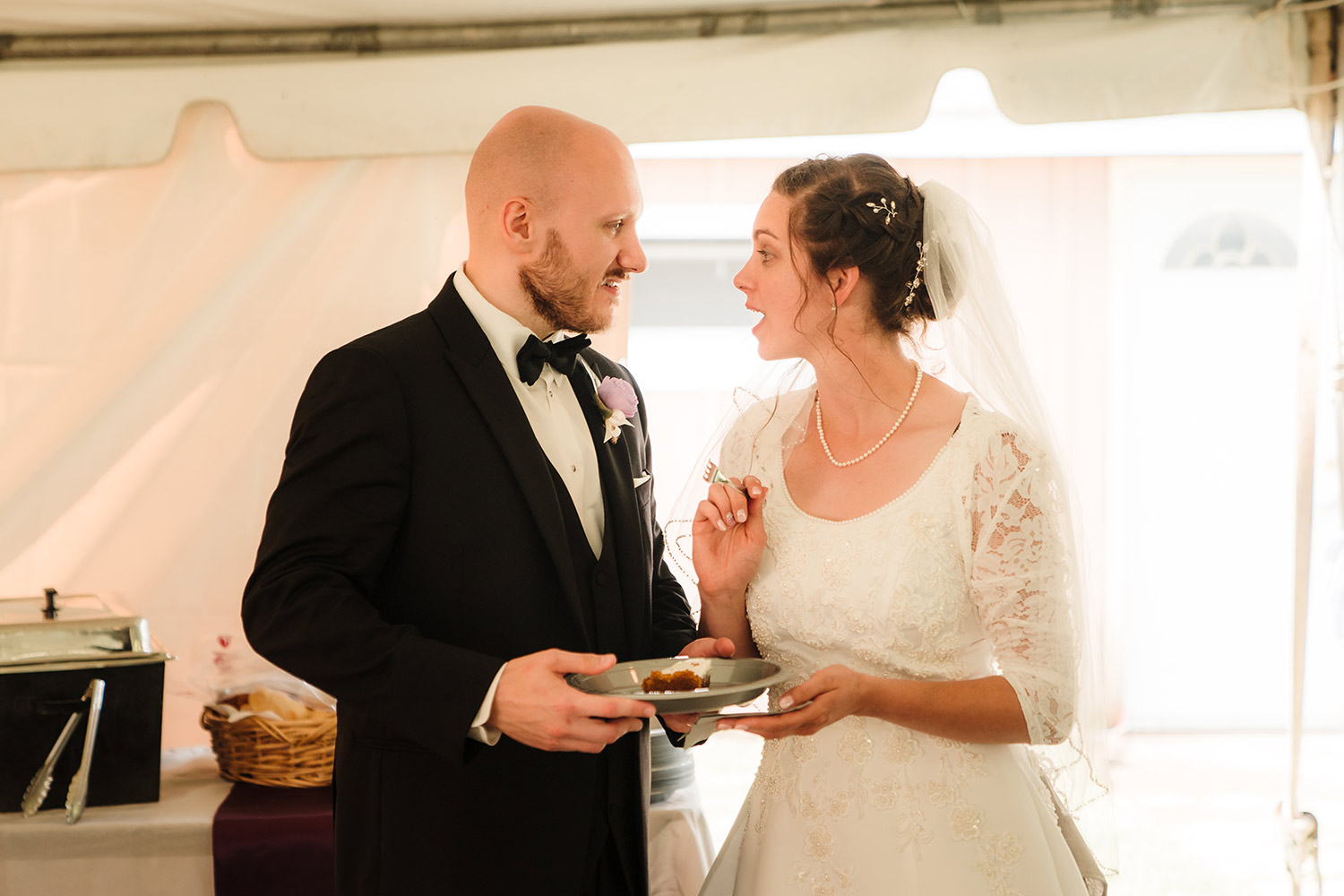 Bride and groom sharing pie at backyard wedding reception