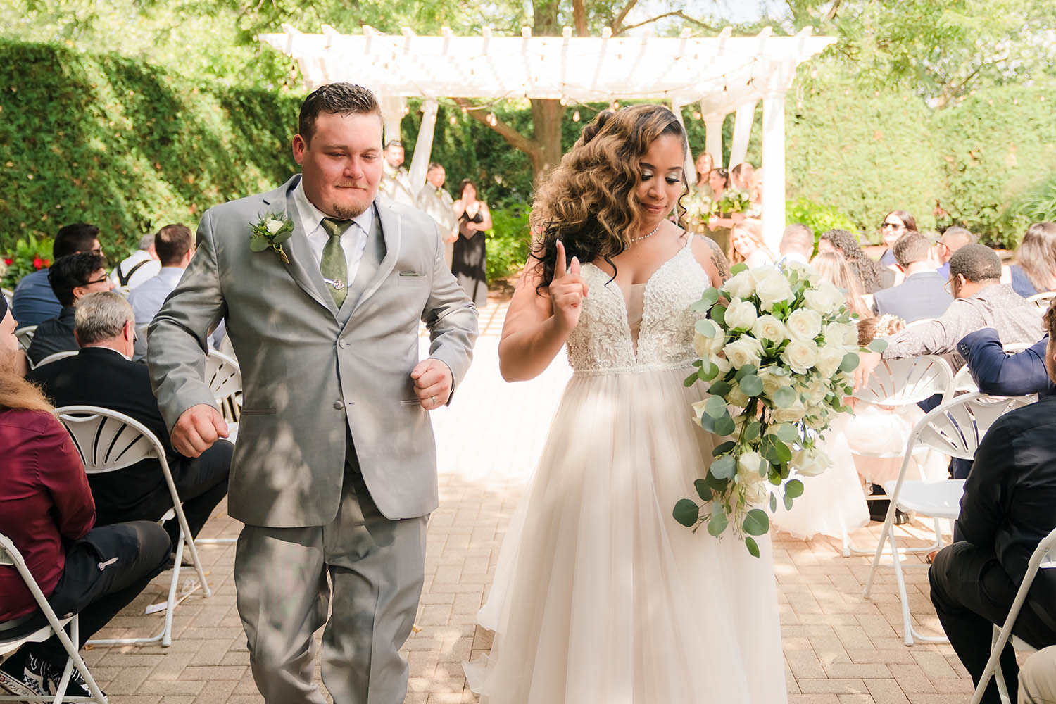 Bride and groom dancing down the aisle during their wedding reception at Orland Chateau in Orland Park, IL