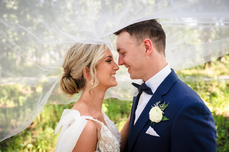 Bride and groom under the veil at Oak Brook Tennis & Bath Club in Oak Brook, IL