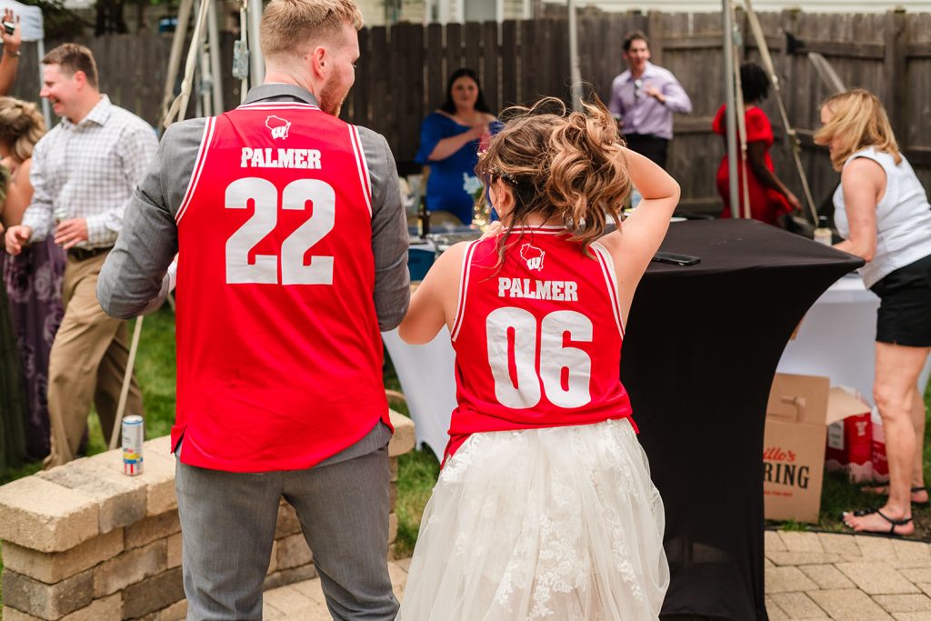 Bride and groom show matching jerseys during their reception in Aurora, IL