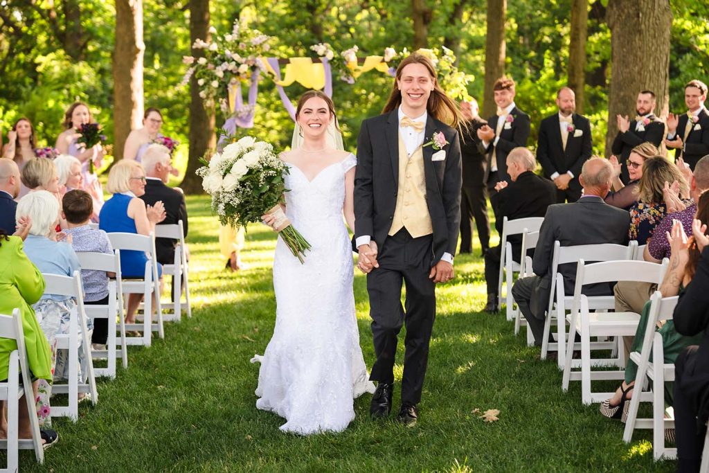 Bride and groom laughing and smiling during their recessional at the Monte Bello Estate in Lemont, IL