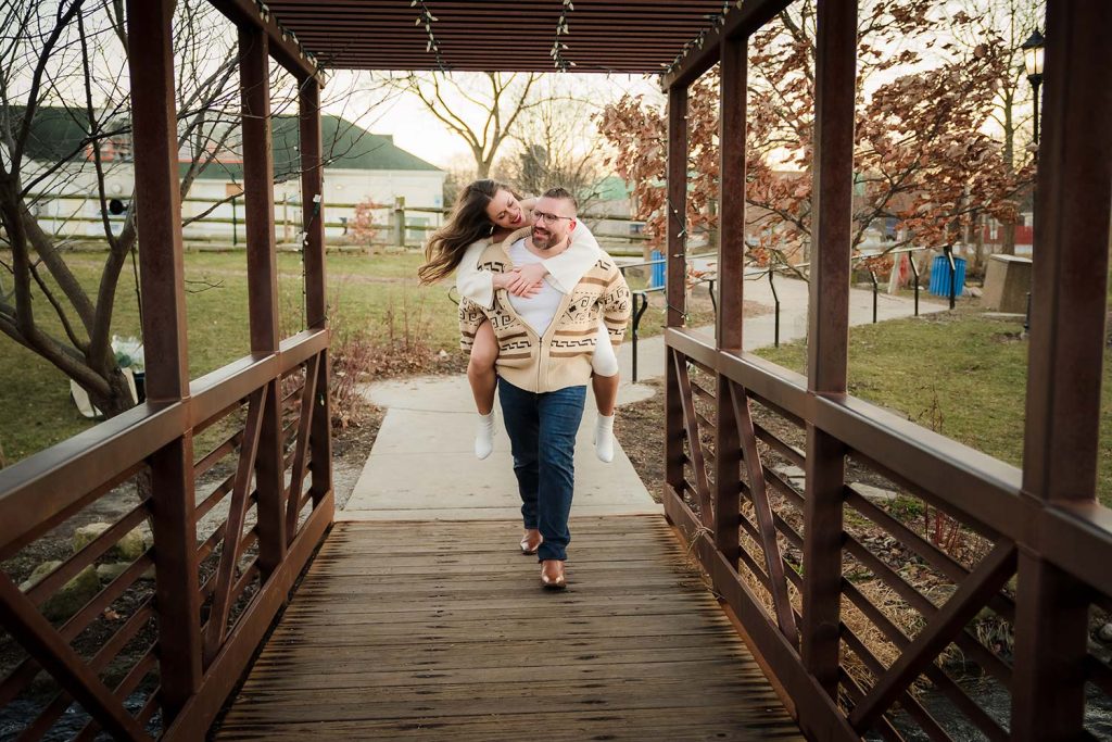 Engaged couple shenanigans on the bridge during their engagement shoot at Lake Katherine in Palos Hills, IL