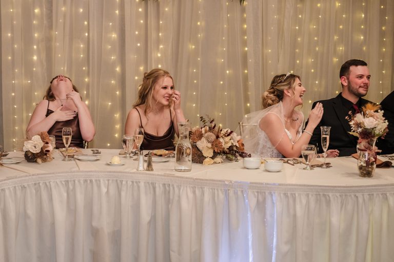 Bridal party laughs and reacts during wedding reception speeches at Aberdeen Manor Ballroom in Valparaiso, IN