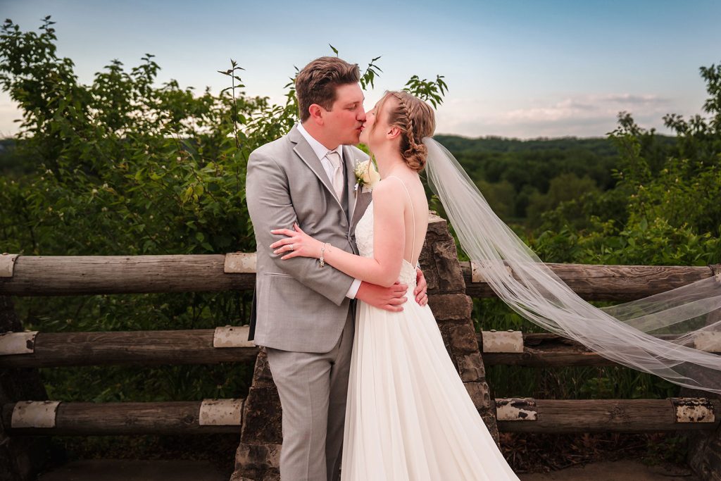 Bride and groom kissing at scenic overlook near Starved Rock Lodge in Oglesby, IL