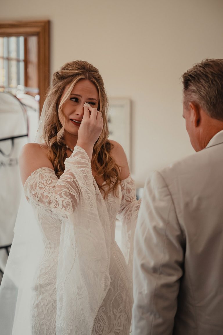 Bride wipes away tears after seeing her father’s emotional reaction during their first look at The BRIX on the Fox in Carpentersville, IL