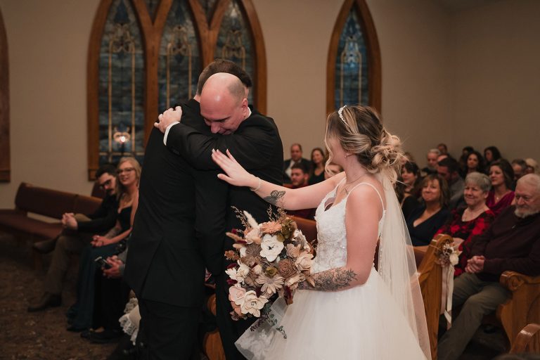 Bride touches her father’s shoulder as he gives her away during the ceremony at Aberdeen Manor Ballroom in Valparaiso, IN