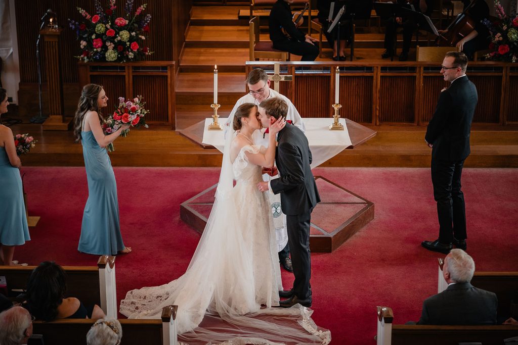 Bride and groom share their first kiss at First United Methodist Church in Elmhurst, IL
