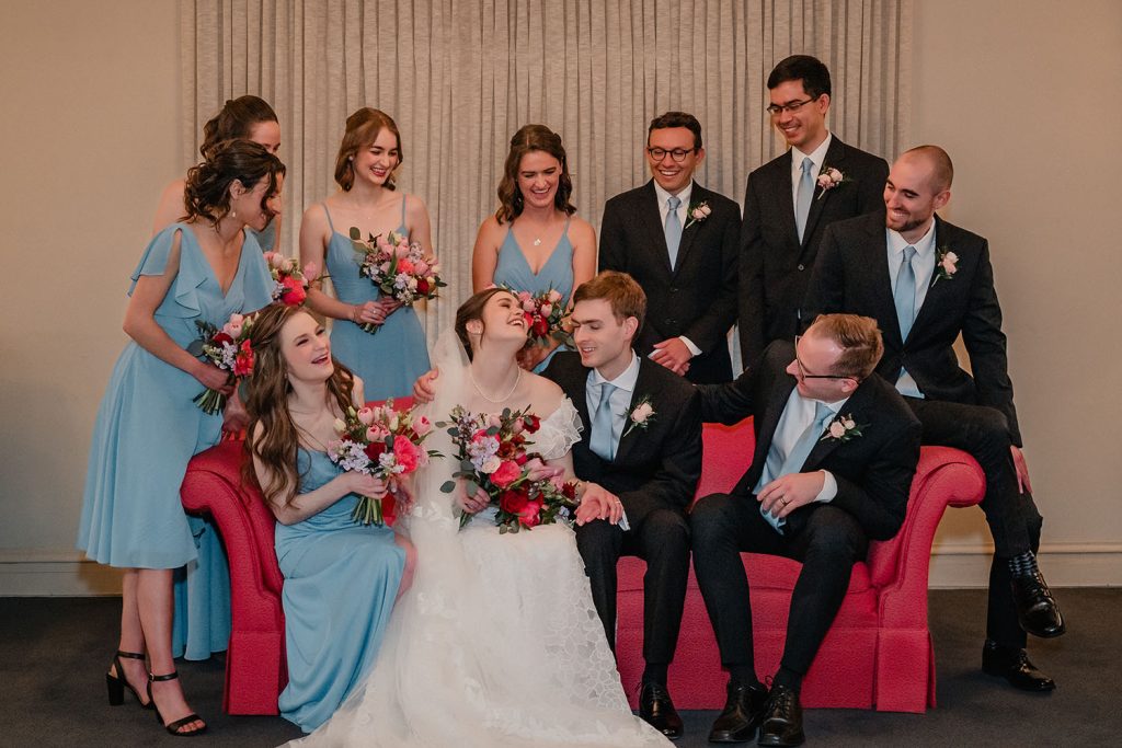 Wedding party laughing together during portraits inside First United Methodist Church in Elmhurst, IL