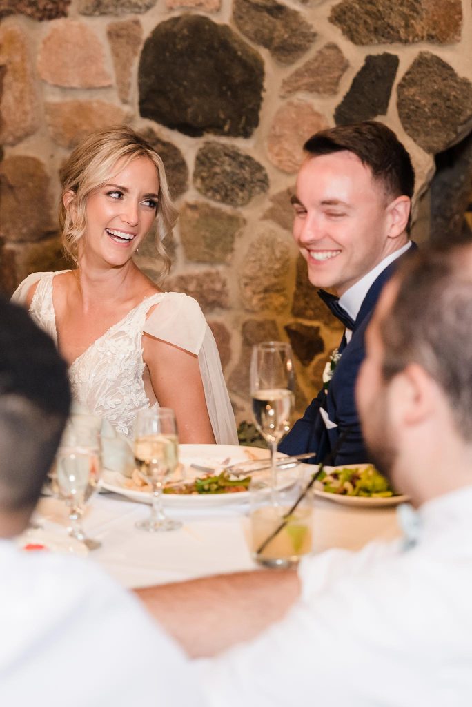 Bride and groom laughing during a heartfelt speech at their wedding reception at Oak Brook Tennis & Bath Club in Oak Brook, IL