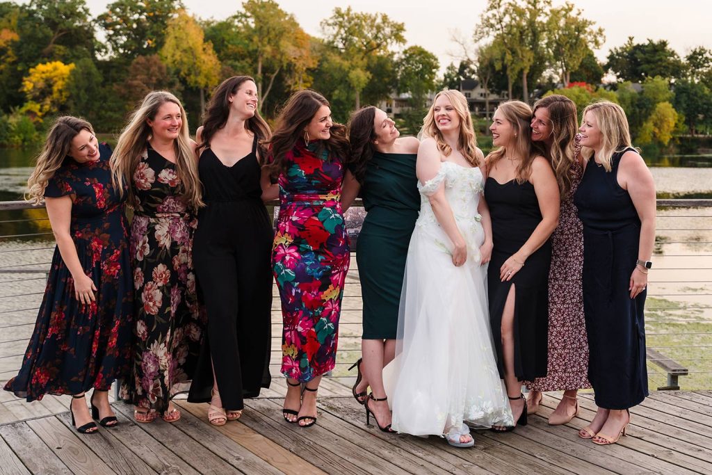 Bride laughs with friends during outdoor cocktail hour at Lake Ellyn Boathouse in Glen Ellyn, IL