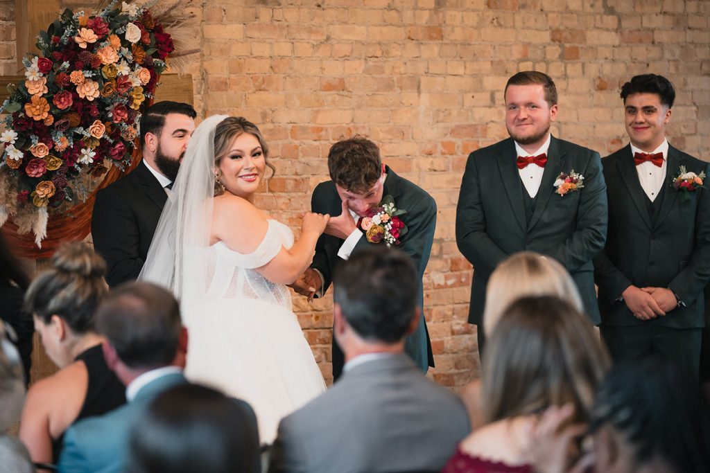 Groom gets emotional during wedding ceremony as bride holds his hand at The BRIX on The Fox in Carpentersville, IL